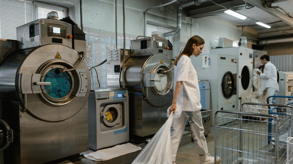 Hospitality laundry staff operating industrial washers—key area for public water system compliance in hotels