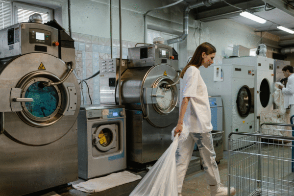 Hospitality laundry staff operating industrial washers—key area for public water system compliance in hotels
